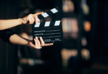 Billion-Dollar Lure Hijacks Hollywood Hands holding a film clapperboard ready for a scene take