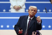 A man in formal attire gesturing during a political event