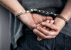 Hands cuffed behind the back, indicating arrest