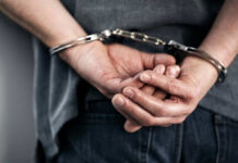 Hands cuffed behind the back, indicating arrest