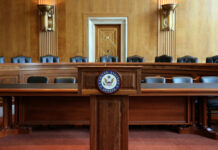 Wooden podium with the United States Senate seal in an empty Senate chamber