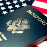 An American passport resting on a background of the USA flag