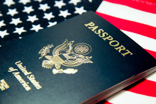 An American passport resting on a background of the USA flag