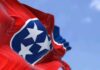 Tennessee state flag waving against a blue sky