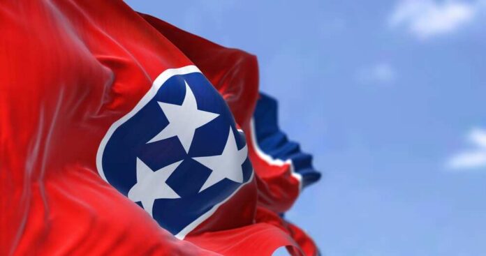 Tennessee state flag waving against a blue sky