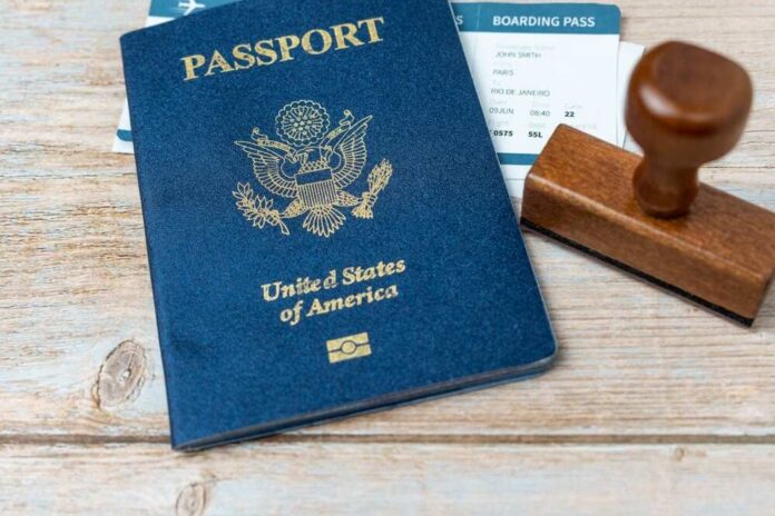 A U.S. passport, boarding pass, and a wooden stamp on a wooden surface