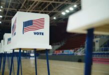 Voting booths with American flags set up in a gymnasium