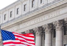 DOJ Settlement Fund Sparks Major Legal Battle Facade of a United States courthouse with an American flag in the foreground
