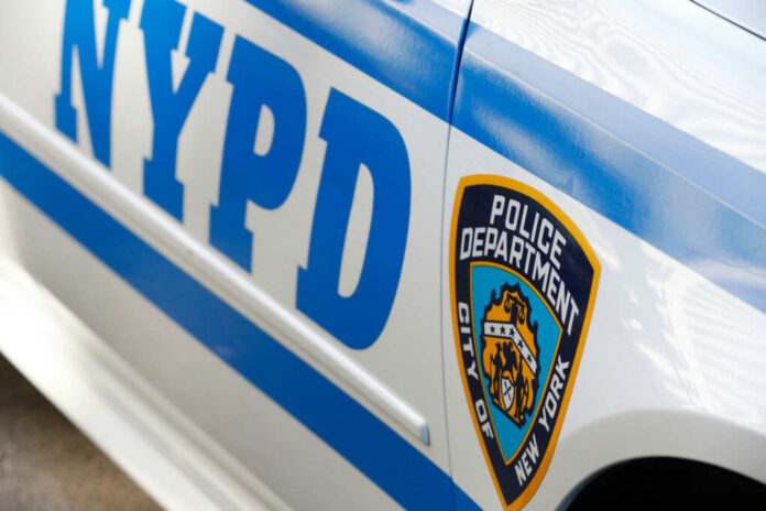 Close-up of a New York Police Department vehicle showcasing the badge and blue stripes