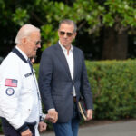 Biden Family Shield EXPOSED — Hunter Speaks Out! Two men walking outdoors, one in a jacket with an American flag, the other in a blazer