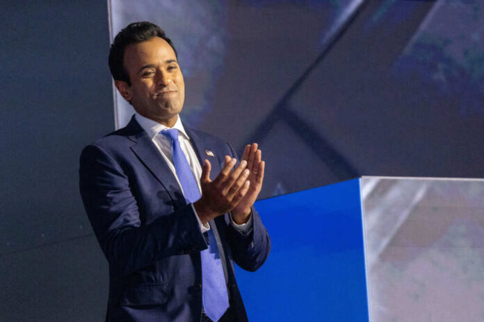 A man in a suit clapping on stage during a presentation
