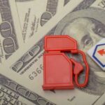 Strategic Reserve Gutted — What’s The Endgame? Red fuel pump toy next to hundred dollar bills