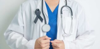 Healthcare professional wearing a white coat and stethoscope, with a black ribbon on their chest