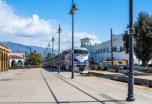 Amtrak train arriving at a station with a scenic backdrop