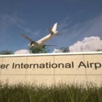 Sign for Denver International Airport with an airplane flying overhead