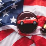 A model red car on a gavel placed on an American flag