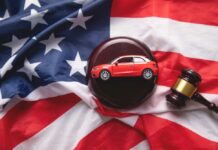 A model red car on a gavel placed on an American flag