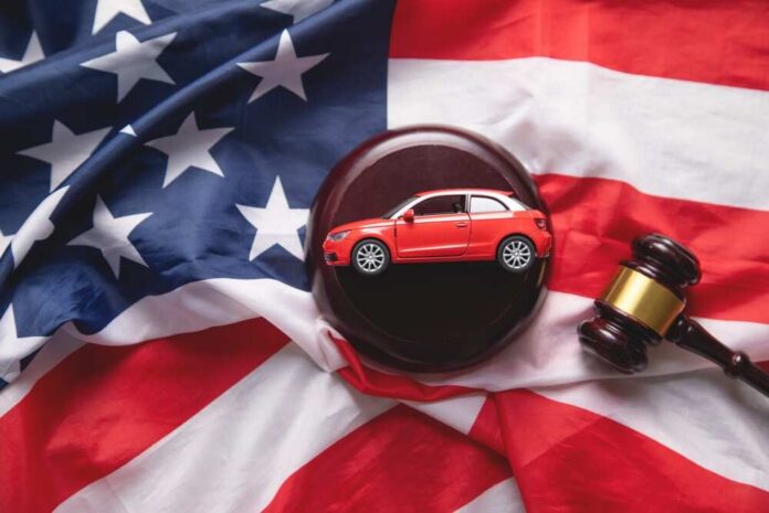 A model red car on a gavel placed on an American flag