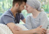 A couple sharing a tender moment, foreheads touching, in a cozy setting