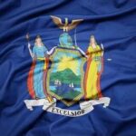 Tax-The-Rich Wave Rocks Democrats New York State flag with coat of arms on blue field