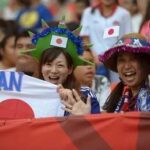 Japanese soccer fans cheering with flags in a stadium