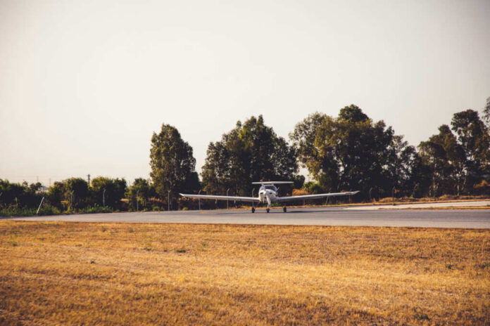 shutterstock1451917139jpg A small airplane on a runway surrounded by trees
