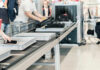 Passengers placing items on a conveyor belt at an airport security checkpoint
