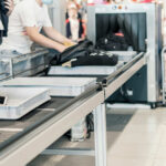 Passengers placing items on a conveyor belt at an airport security checkpoint