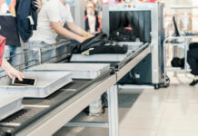 Passengers placing items on a conveyor belt at an airport security checkpoint