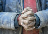 Cheap Labor Scam Finally Unmasked Close-up of dirty hands clasped together, wearing a blue jacket