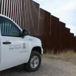 Zero Releases Claim Sparks Border Uproar U.S. Customs and Border Protection vehicle parked near a border wall in a desert area