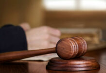 Murder Convict Wants Taxpayer-Funded Appeal A wooden gavel on a desk with a blurred hand in the background reviewing documents