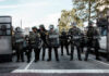 Economic Crisis Sparks Migrant Protests Law enforcement officers in riot gear standing in formation