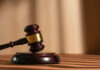 Shocking School Stabbing Videos Released A wooden gavel resting on a circular base with soft lighting