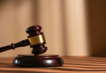 Shocking School Stabbing Videos Released A wooden gavel resting on a circular base with soft lighting