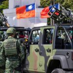 U.S. Halts $14 Billion Taiwan Deal Soldiers in camouflage uniforms standing near military vehicles with flags in the background
