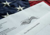 An official election ballot placed on an American flag background