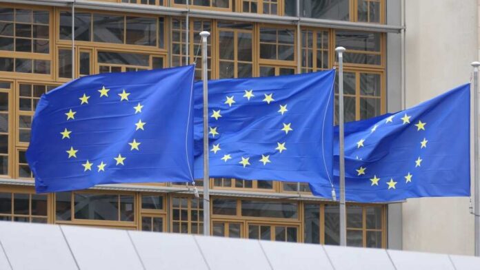 European,Flags,Flying,In,Brussels Three European Union flags waving in front of a building