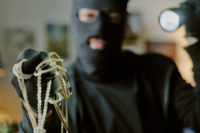 masked person holding jewelry and pearls