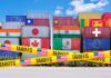 Trump Threatens 100% Tariffs on Europe Stacked shipping containers with national flags behind yellow tariffs tape