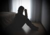 Billionaire Mogul Accused — Victims Speak Out A silhouette of a woman sitting on the floor, appearing contemplative and distressed