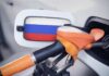 Fuel nozzle inserted into a car with a flag-themed fuel door