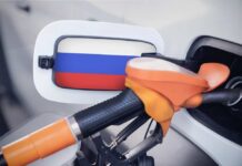 Fuel nozzle inserted into a car with a flag-themed fuel door