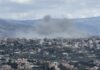 Strikes Continue Despite Peace Efforts Smoke rising from a city in a mountainous area