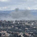 Strikes Continue Despite Peace Efforts Smoke rising from a city in a mountainous area