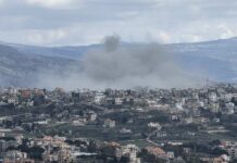 Smoke rising from a city in a mountainous area