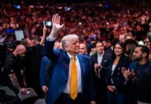 Trump Visit Triggers Midtown Lockdown A man in a blue suit with a yellow tie waves to a cheering crowd