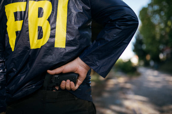Cropped,Photo,Of,Fbi,Agent,In,Action,With,A,Pistol, FBI agent gripping handgun near waistband outdoors