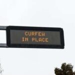 Electronic road sign displaying curfew notice