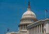 DOJ Nominee Faces Tough Hearing United States Capitol dome with American flags against a blue sky